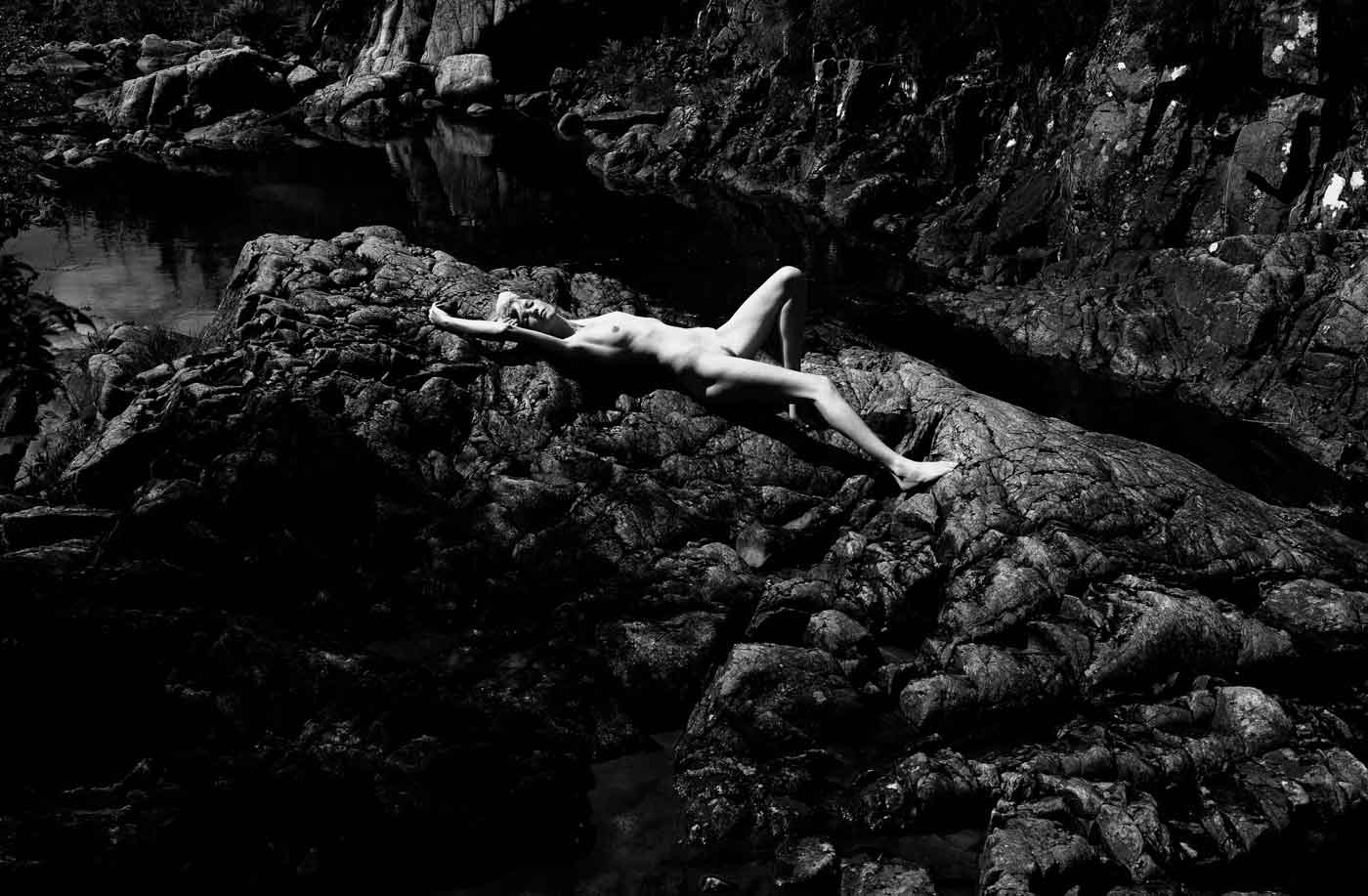 Nude photography: naked female on rocks