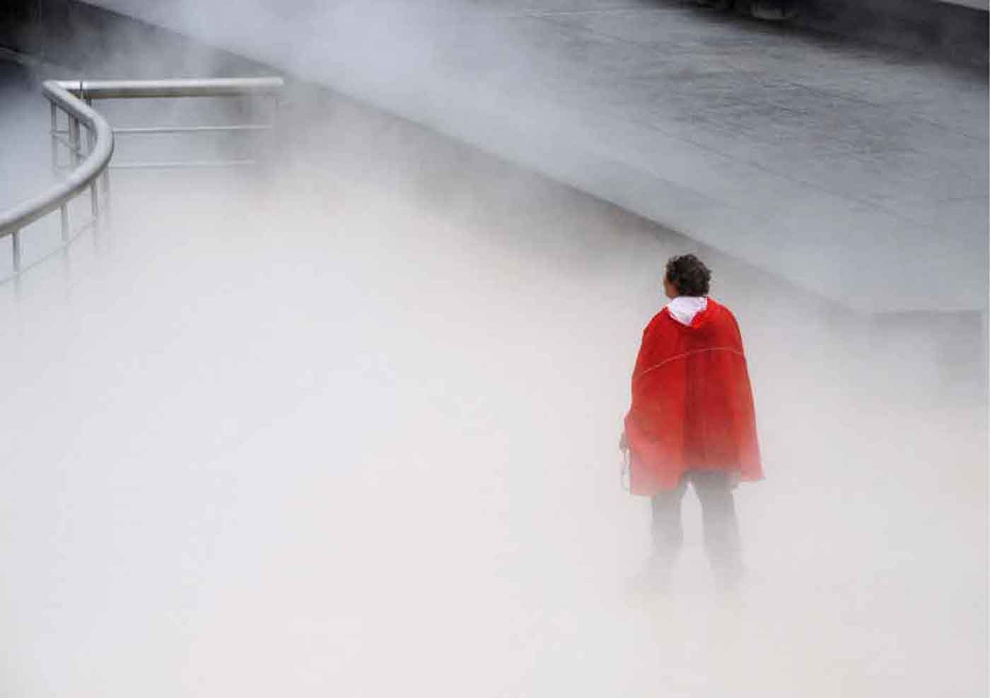 Reportage Photography: lady in red waterfall mist